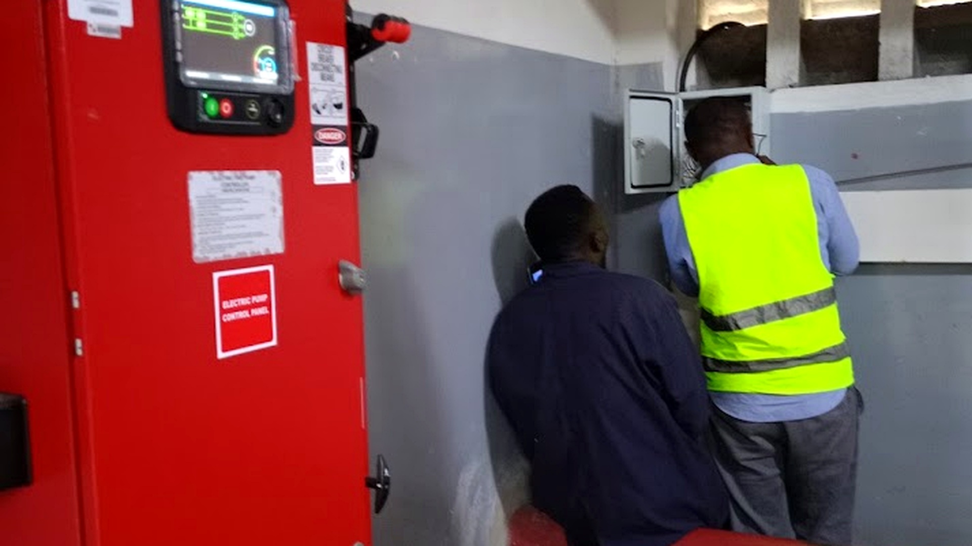 Technicians installing pump control panel at Somerset property
